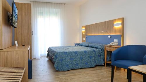 una camera d'albergo con letto, scrivania e sedia di Hotel Marina a Bardolino