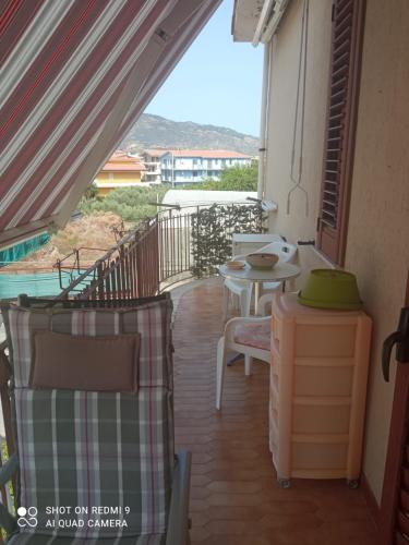 un balcón de una casa con mesa y sillas en Baia blu falcone, en Falcone
