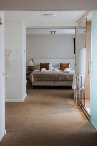 a bedroom with a bed with a large mirror at Hotel Lugano in Knokke-Heist
