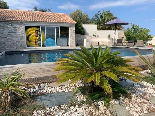 a swimming pool with a palm tree next to a house at Magnifique maison avec vue mer hauteur de Bastia in Bastia