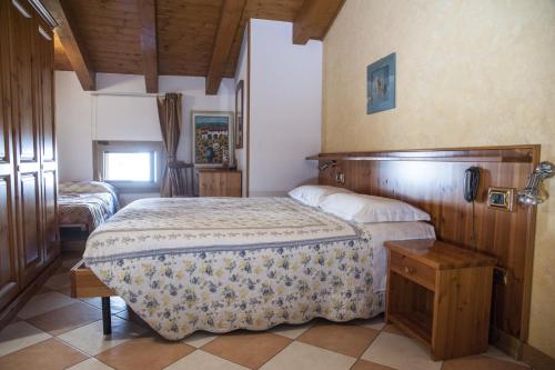 a bedroom with a large bed with a wooden headboard at Casa Hellen in Monteforte dʼAlpone