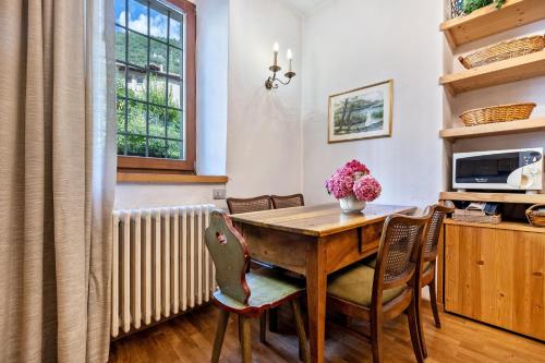 a dining room with a wooden table and chairs at Casa nel Borgo Iris in Breguzzo