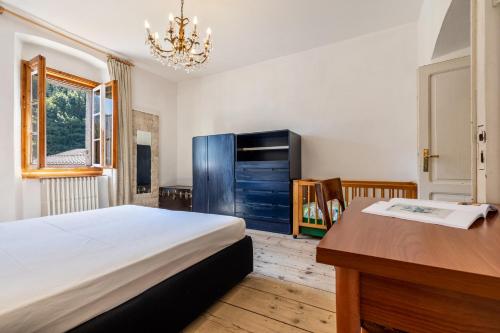 1 dormitorio con escritorio, 1 cama y escritorio sidx sidx sidx en Casa nel Borgo Iris, en Breguzzo