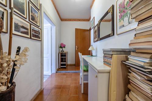 a hallway with a pile of books on a wall at Casa nel Borgo Iris in Breguzzo
