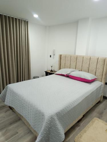 1 dormitorio con 1 cama blanca grande con almohadas en Apartamento en Tunja en Tunja