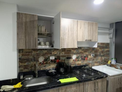 a kitchen with wooden cabinets and a counter top at Apartamento en Tunja in Tunja