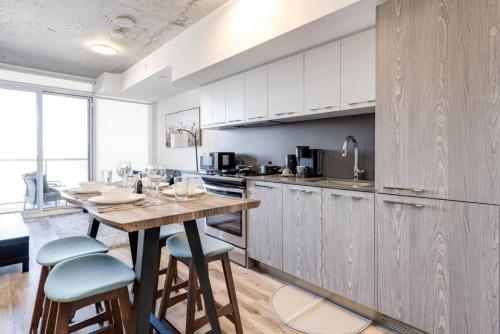 a kitchen with a wooden table and chairs and a counter at South Riverdale Suite with High speed WiFi and Balcony in Toronto