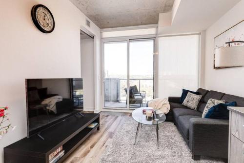 a living room with a couch and a table at South Riverdale Suite with High speed WiFi and Balcony in Toronto