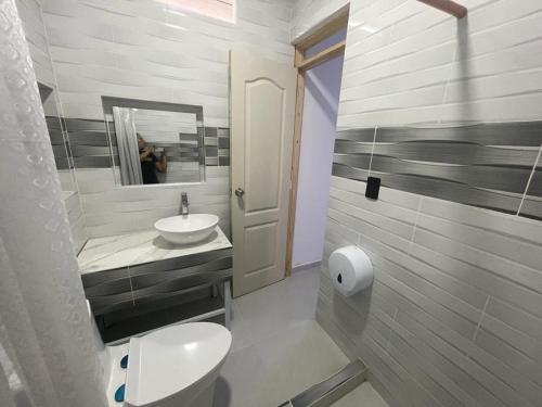 a bathroom with a toilet and a sink and a mirror at Casa bella de campo Wifi billar piscina bolirana !privado! in Carmen de Apicalá