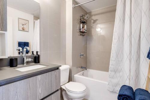 a bathroom with a toilet and a sink and a bath tub at South Riverdale Suite with High speed WiFi and Balcony in Toronto