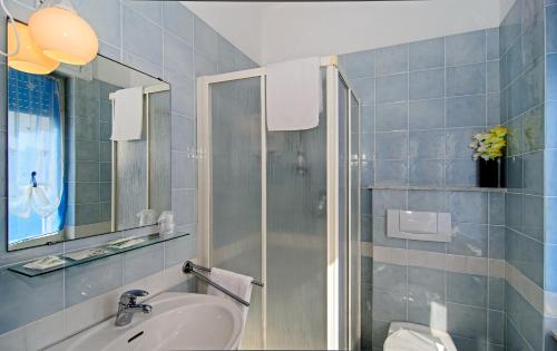 een badkamer met een wastafel en een douche bij Hotel Scandinavia in Marina di Massa