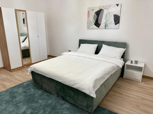 ein Schlafzimmer mit einem großen Bett und einem Spiegel in der Unterkunft Apartman Maja in Srbobran