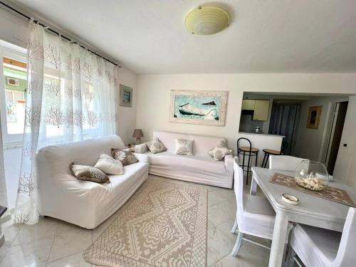 a living room with a white couch and a table at [ Appartamento a Golfo Aranci ] in Golfo Aranci