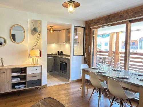 une cuisine et une salle à manger avec une table et des chaises dans l'établissement Appartement de standing avec WIFI et parking, au centre de la station - FR-1-623-97, aux Gets