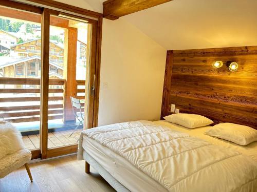 une chambre avec un lit et une grande fenêtre dans l'établissement Appartement de standing avec WIFI et parking, au centre de la station - FR-1-623-97, aux Gets