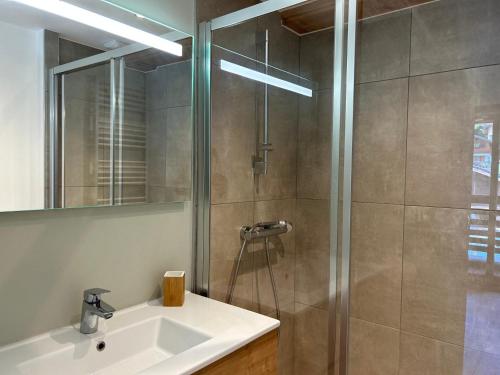 une salle de bain avec un lavabo et une douche dans l'établissement Appartement de standing avec WIFI et parking, au centre de la station - FR-1-623-97, aux Gets