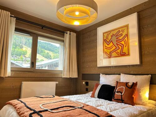 une chambre avec un lit et une grande fenêtre dans l'établissement Appartement de Standing au Coeur des Gets, 3 Chambres, 10 Couchages, Parking, Proche Pistes et Commerces - FR-1-623-296, aux Gets
