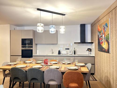 une cuisine avec une table en bois entourée de chaises. dans l'établissement Appartement de Standing au Coeur des Gets, 3 Chambres, 10 Couchages, Parking, Proche Pistes et Commerces - FR-1-623-296, aux Gets