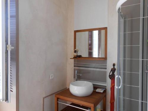 une salle de bain avec un lavabo blanc et un miroir dans l'établissement TyChrystel, à Penmarcʼh