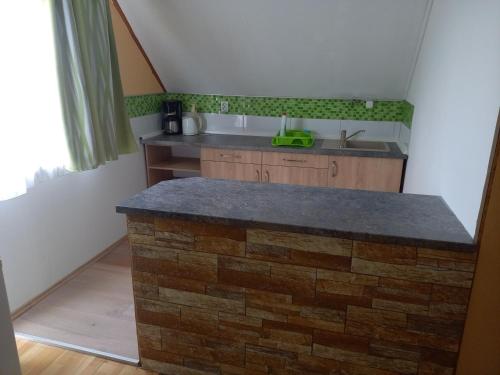 a kitchen with a stone island in a room at Patrícia Panzió in Bük