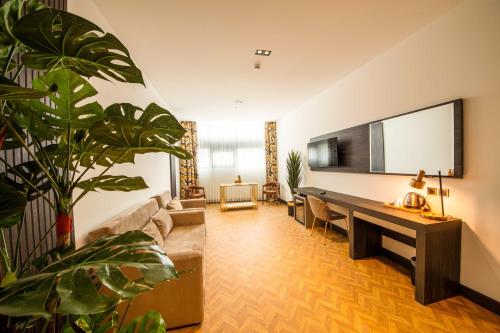 a living room with a desk and a large plant at V Center Hotel in Trabzon