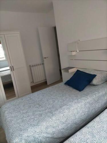 a bedroom with a bed with a blue pillow at Piso recién reformado con balcón in Haro