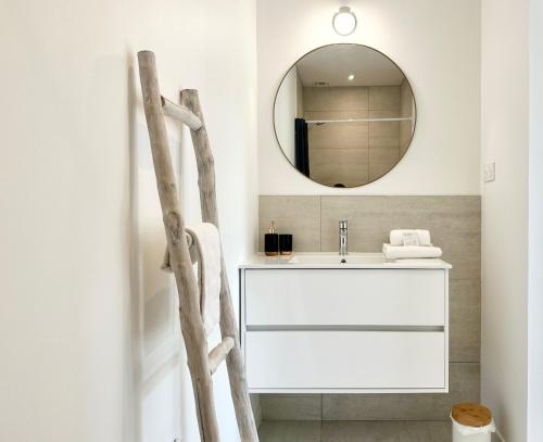 y baño con lavabo blanco y espejo. en LES ARÈNES - Lumineux - Centre-Ville en Mont-de-Marsan