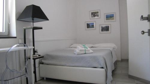 a white bedroom with two beds and a lamp at SOHO B&B in Fisciano