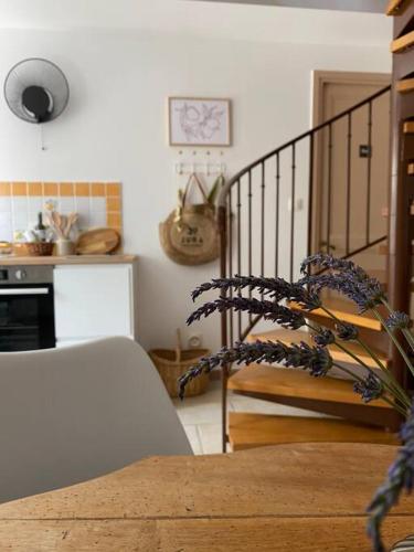 a living room with a table and a spiral staircase at L'Alambic à Martial in Ménétru-le-Vignoble