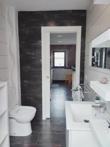 een badkamer met een toilet en wastafel en een keuken bij Agarimo Home in Virxe das Mareas