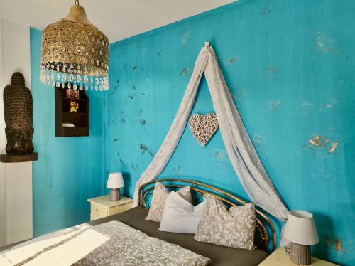 1 dormitorio con 1 cama con pared azul en Nature Finca Apartment - Pure Relaxation en Mazo