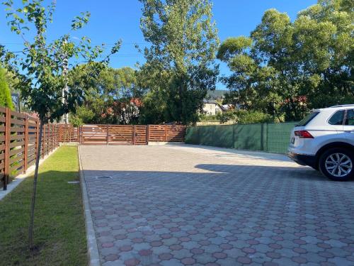 a car parked in a driveway next to a fence at Pensiunea Casa Alexandra in Vatra Dornei