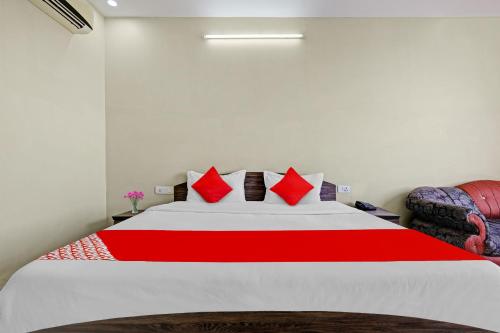 sypialnia z dużym łóżkiem z czerwonymi poduszkami w obiekcie SPOT ON 81091 Gmall w mieście Haldwani