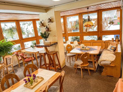 een restaurant met tafels, stoelen en ramen bij Penzion Limba in Demanovska Dolina