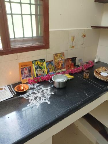a kitchen counter with a counter top with pictures on it at Home Stay in Tribhuvanam