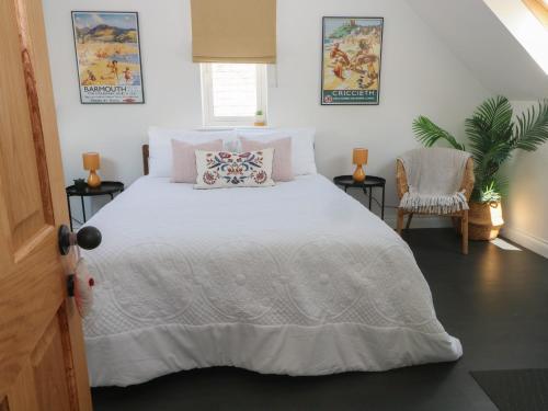 um quarto com uma cama grande e um edredão branco em Bodlywydd Fawr - Annexe em Ruthin