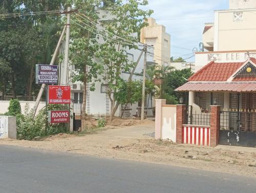 a street with signs in front of a house at Home Stay in Tribhuvanam