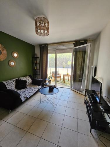 ein Wohnzimmer mit einem Sofa und einem Tisch in der Unterkunft Cosy T2 entre terre et mer in Montpellier