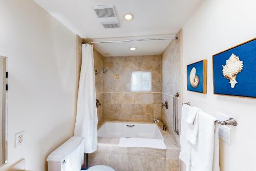 a bathroom with a bath tub and a toilet at Manchester Escape in Santa Barbara