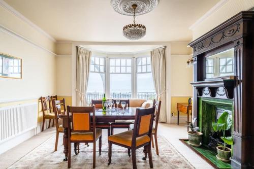 a dining room with a table and a fireplace at Magnificent house with Harbour view - Ramsgate in Ramsgate
