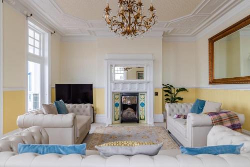 a living room with white furniture and a fireplace at Magnificent house with Harbour view - Ramsgate in Ramsgate