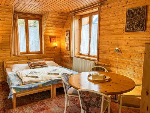 a bedroom with a bed and a table and chairs at Penzion Limba in Belá