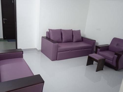 a purple couch and two chairs in a room at Purple passion in Ranipet