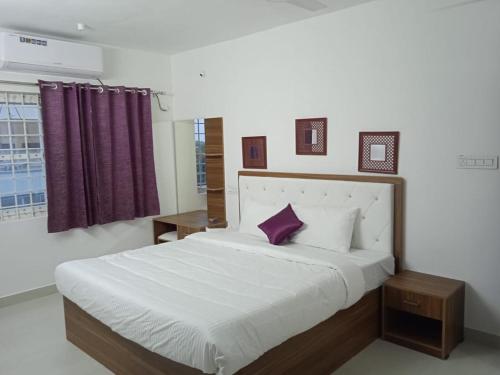 a bedroom with a large bed with a purple pillow at Purple passion in Ranipet