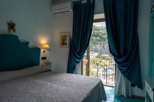 a bedroom with a bed and a large window at Palazzo Vingius in Minori