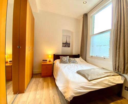 a small bedroom with a bed and a window at Cosy flat in Central LDN Payment to the HOST in London