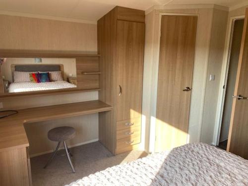 a bedroom with a bed and a desk and a chair at Mwnt Sea View Caravan with Free WiFi in Cardigan