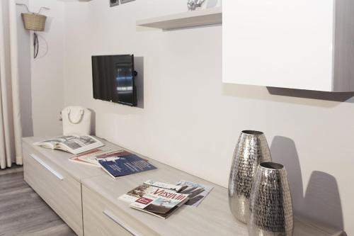 sala de estar con mesa y TV en la pared en Flat 252 Sorrento Apartments, en Sant'Agnello
