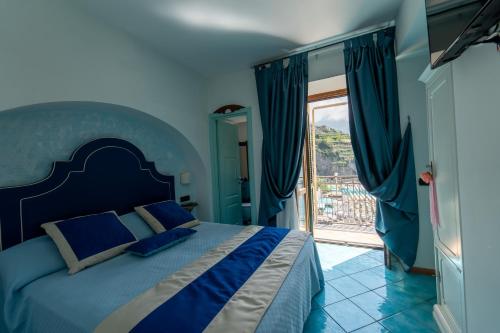 a blue bedroom with a bed and a sliding glass door at Palazzo Vingius in Minori