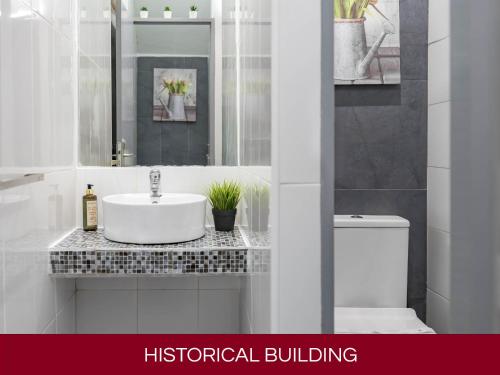 Baño blanco con lavabo y aseo en Casa Senhoras Rainhas AL - Obidos - by Unlock Hotels, en Óbidos